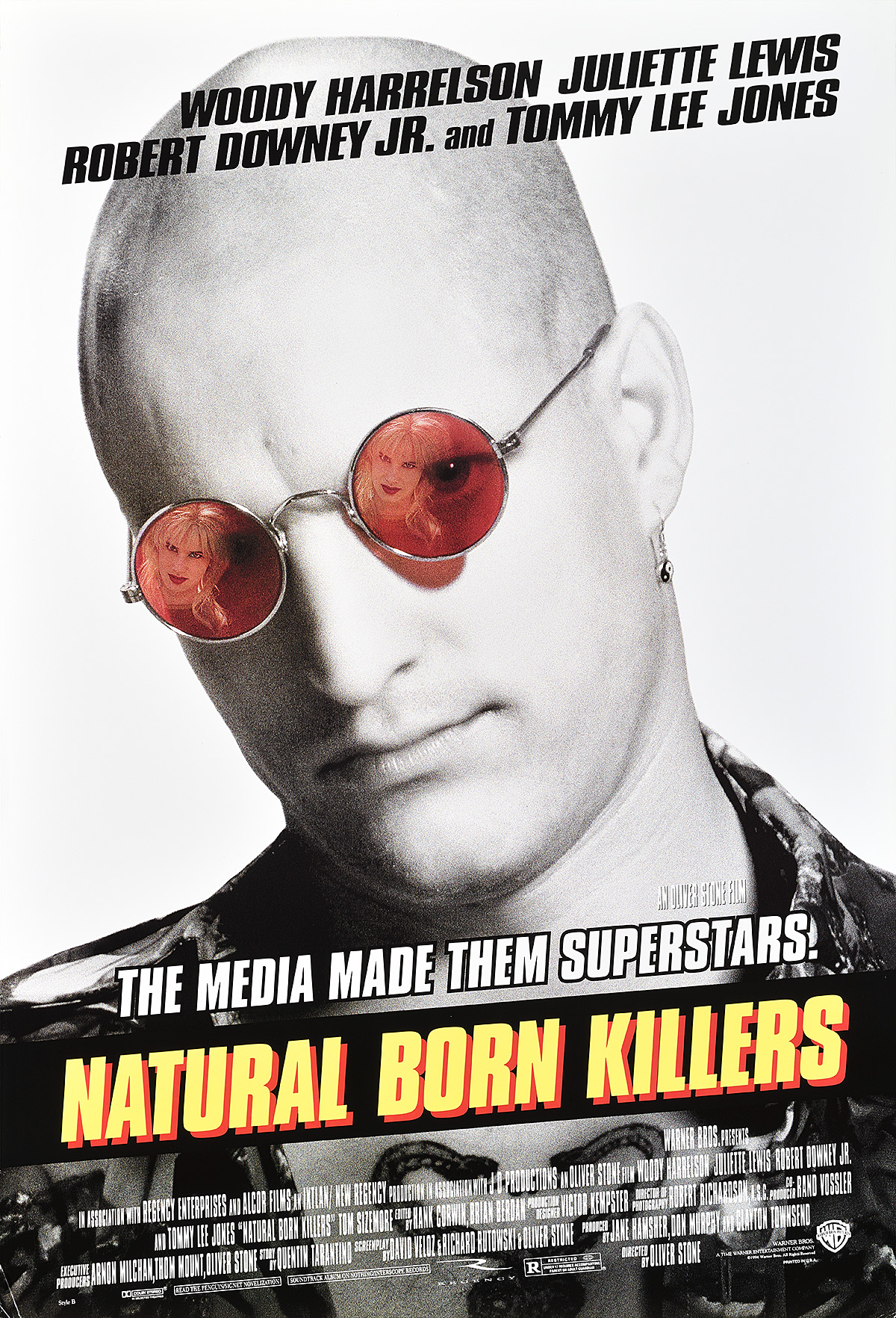 A poster of a bald man wearing red sunglasses, with a blonde woman in the reflection.