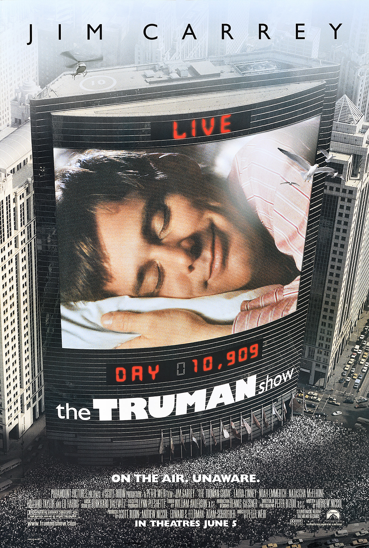 A poster of a TV screen billboard in a city with a sleeping man under text stating 'Live.'