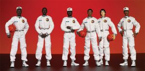 An image of 6 action figures wearing white flight suits and holding basketballs.