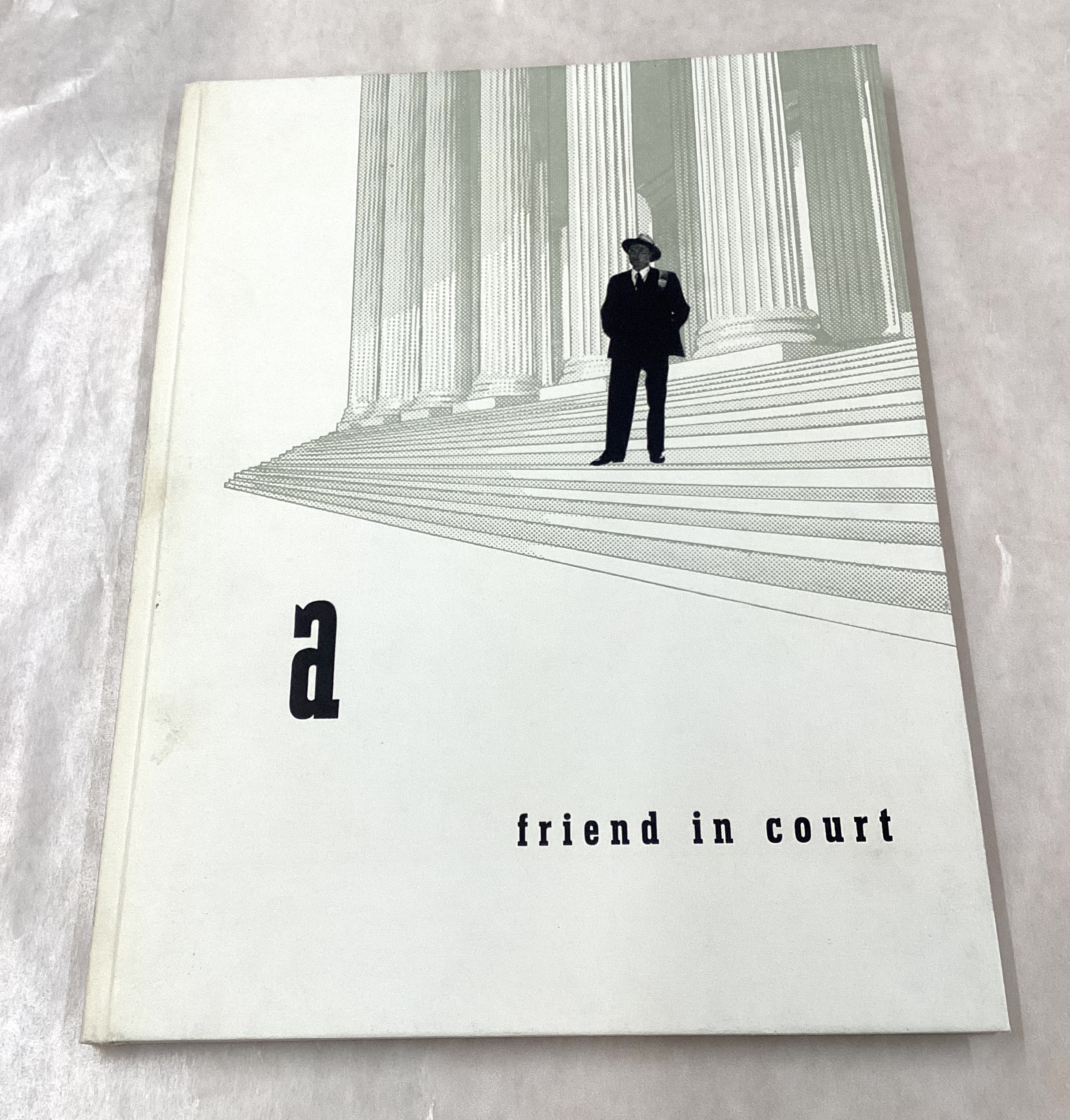 A book with a black-and-white image of a man in a suit on the steps of a courthouse.