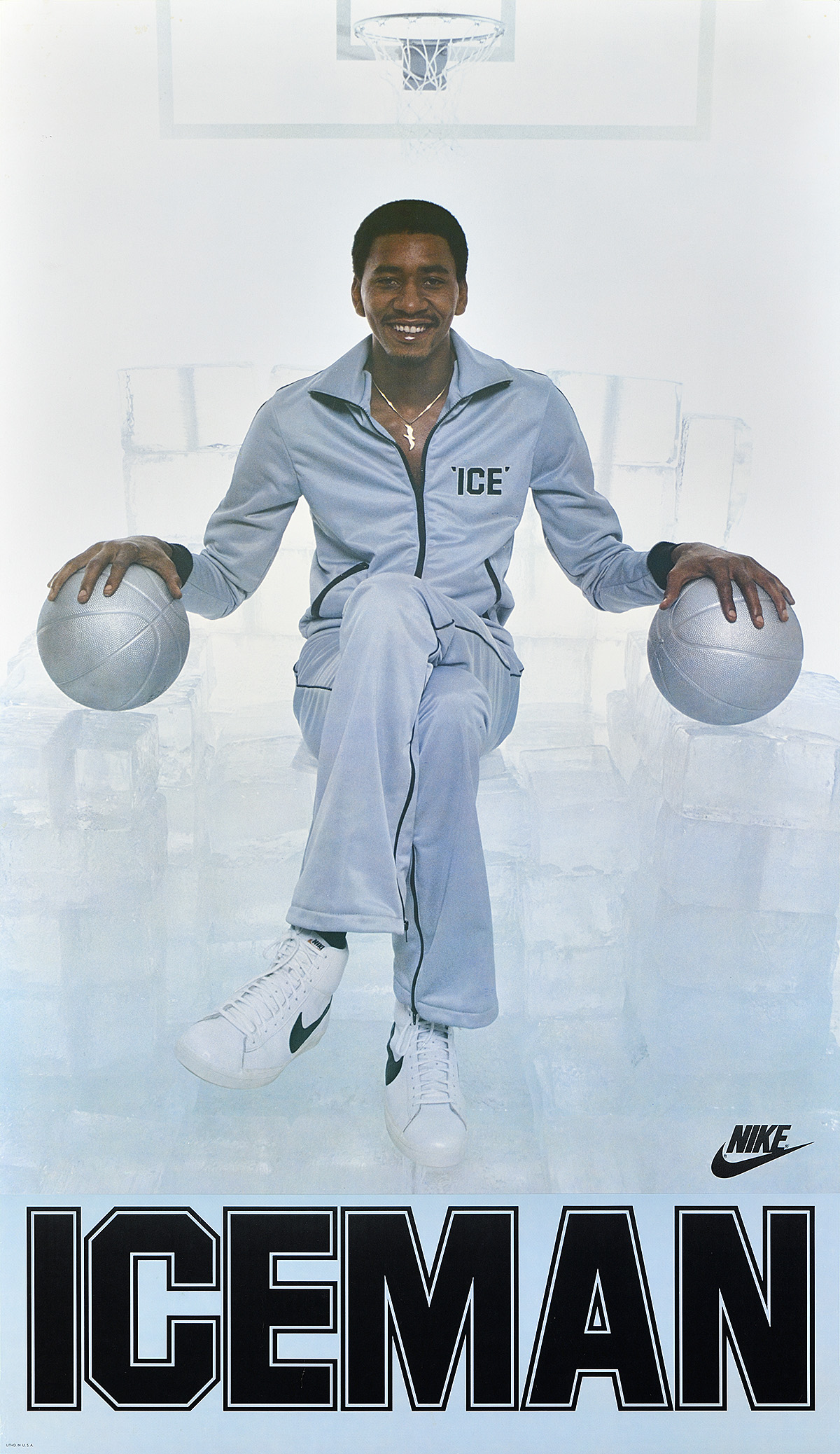 A poster of a seated Black man in a white tracksuit, his hands resting on 2 white basketballs.