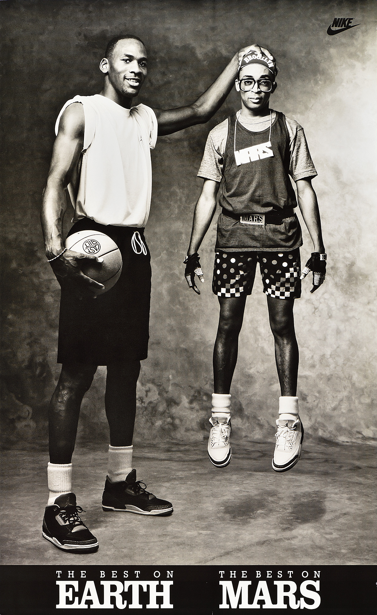 A poster of a tall Black man holding a basketball and lifting a short Black man by the top of his head.