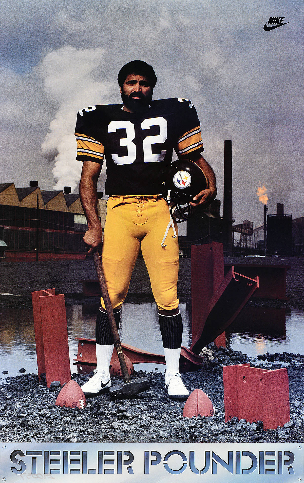 A poster of a man with dark skin in a football uniform holding a sledgehammer with a split football at his feet.