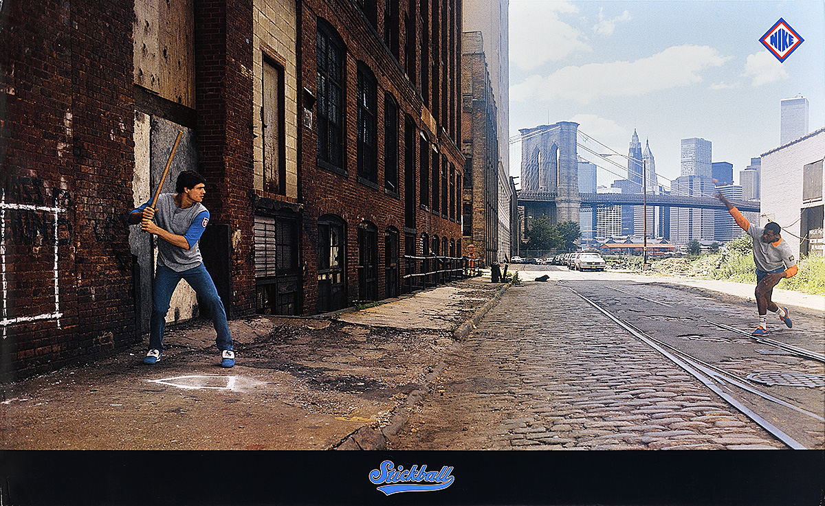 A poster of 2 men playing stickball on a cobbled street with the Brooklyn Bridge in the background.