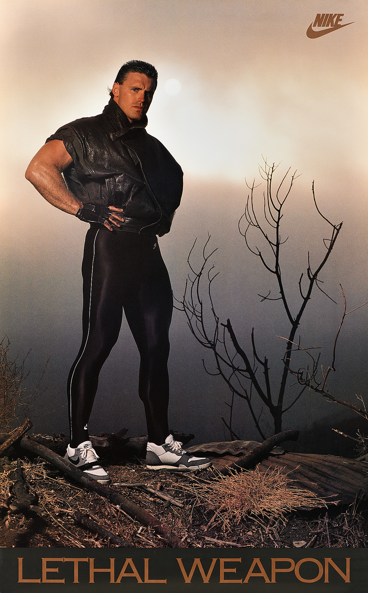 A poster of a white man in a barren landscape wearing Nike shoes with his hands on his hips.