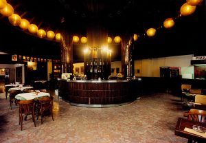 A photo of a restaurant with circular lanterns and slats, showcasing the circular bar.