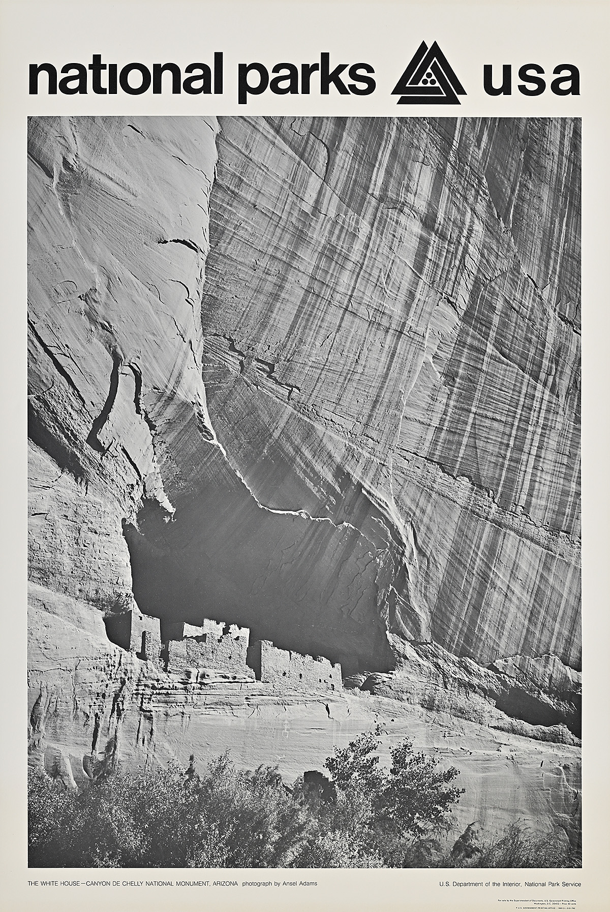 A poster of a black and white photograph of the base of a cliff.