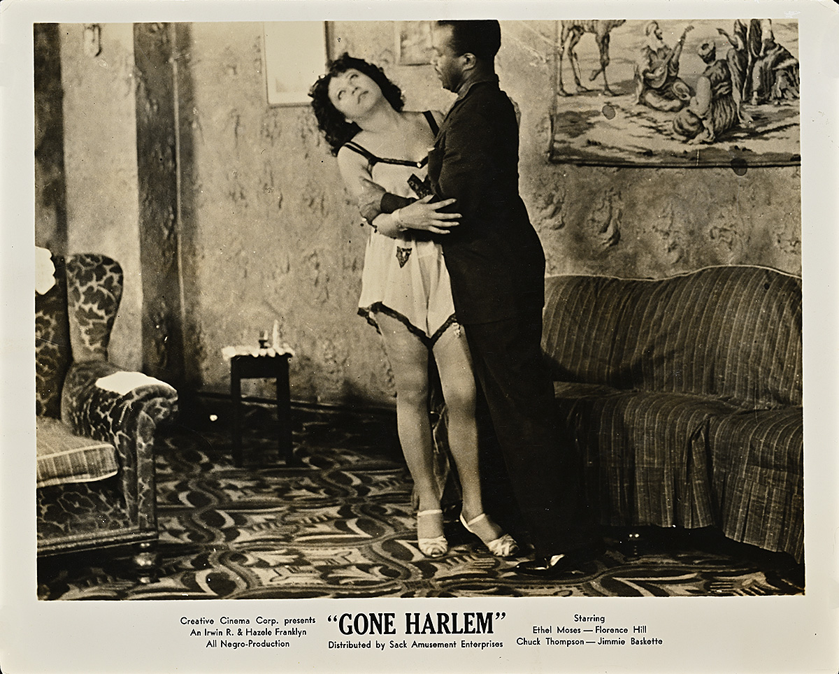 A printed card with a black and white photograph of a Black man embracing a woman in a nightgown.