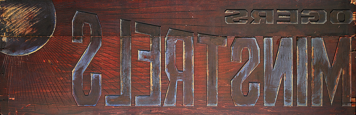 A red toned wooden printing block with backward text.