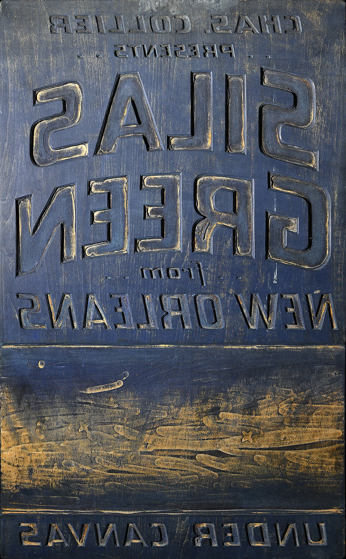 A wooden printing block with backward text.