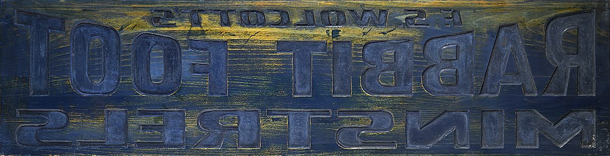 A wooden printing block with backward text.