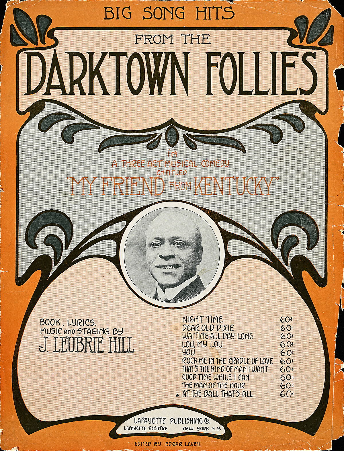 A small circular black and white photograph of a man's face in the center of an art nouveau design.