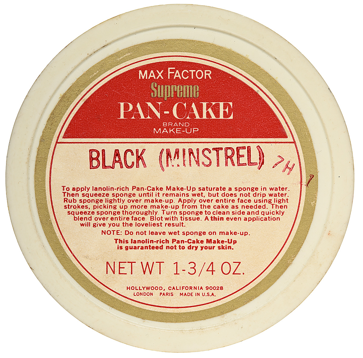 The top of a white circular container with a gold outline and red and white text.