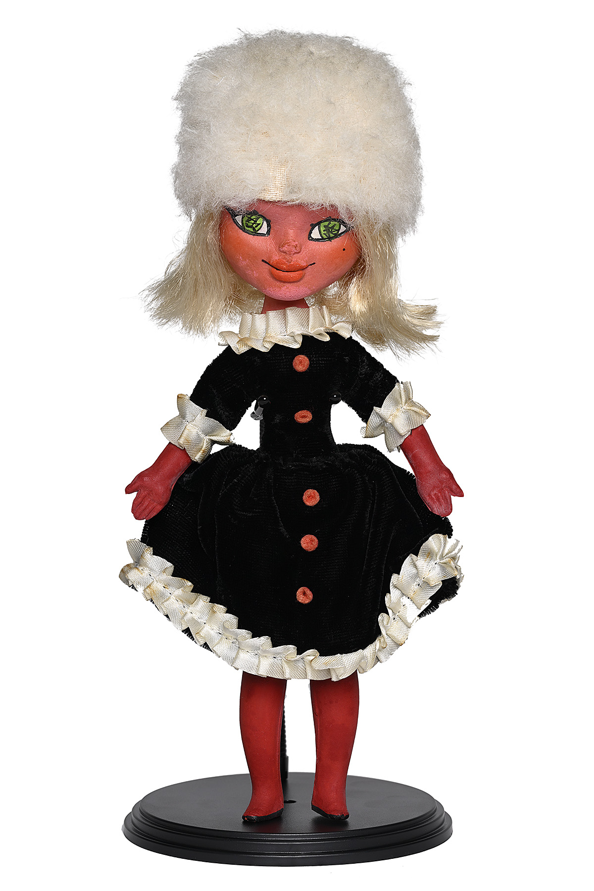 A female figurine wearing a white fur hat and a black dress.