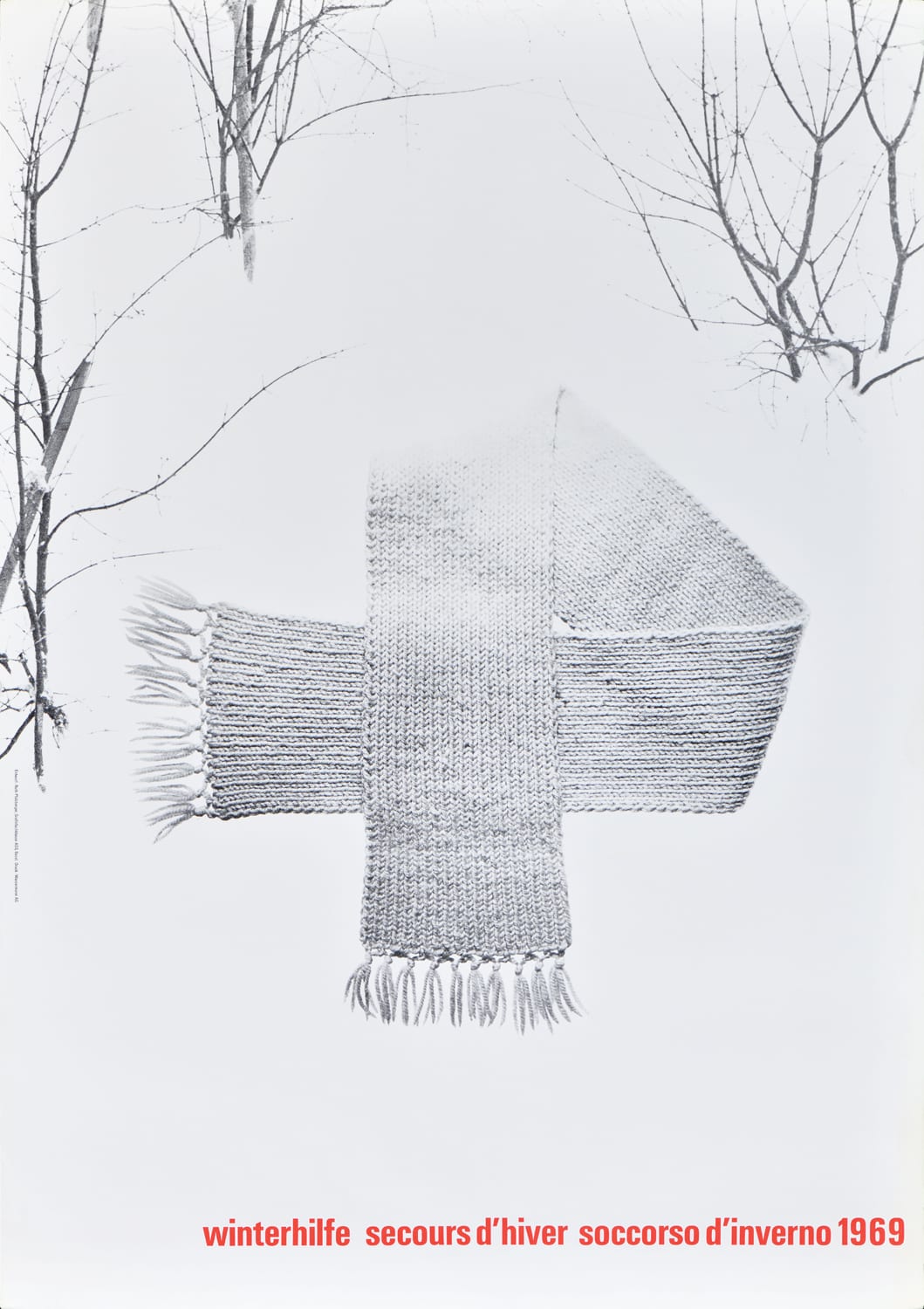 A poster of a winter landscape with a scarf folded in the formation of a cross in the center.